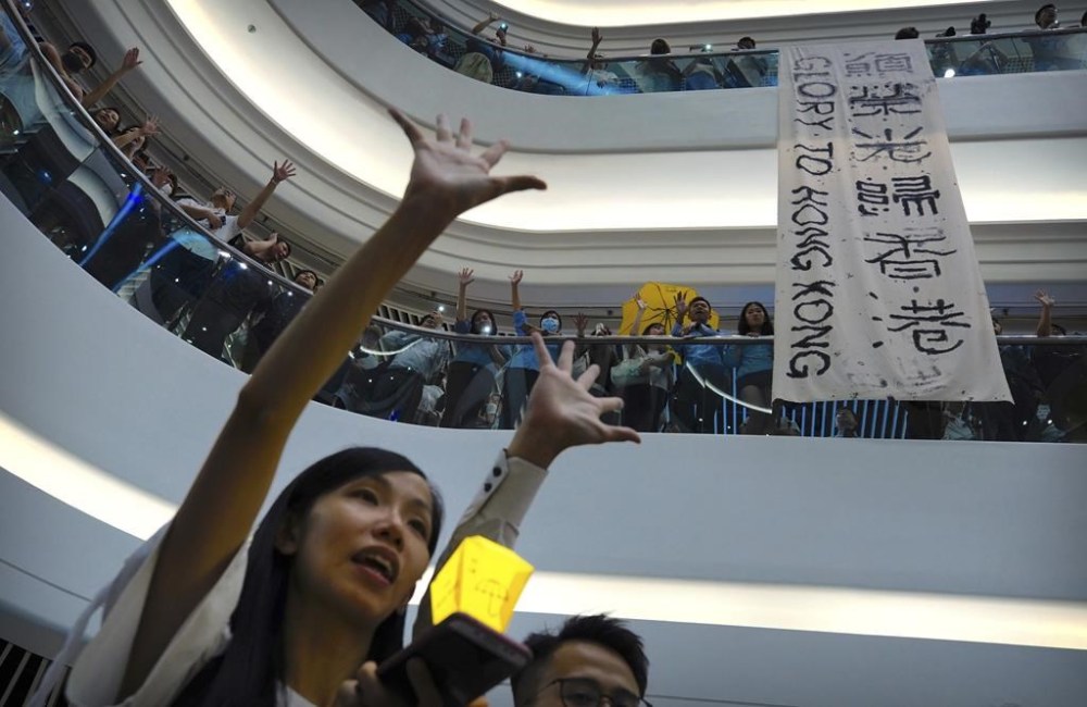 FILE - Demonstrators sing a theme song written by protestors