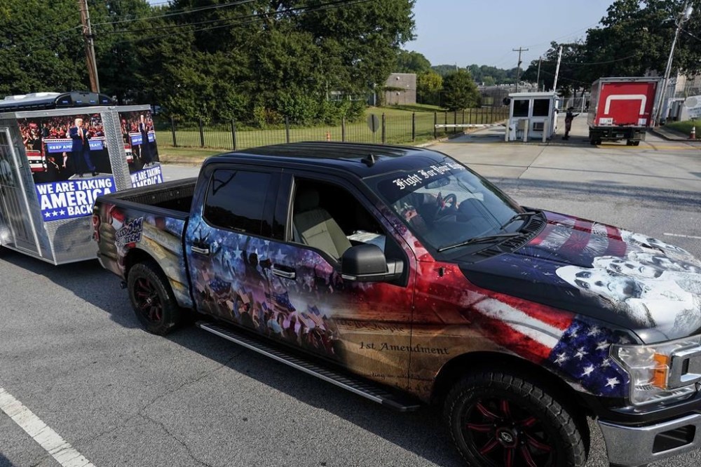 A vehicle and trailer drive by the Fulton County Jail, Thursday, Aug. 24, 2023, in Atlanta. Former President Trump is charged alongside others, who are accused by Fulton County District Attorney Fani Willis of scheming to subvert the will of Georgia voters to keep the Republican president in the White House after he lost to Democrat Joe Biden. (AP Photo/Mike Stewart)