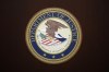 FILE - The U.S. Department of Justice logo is seen on a podium following a news conference in the office of the U.S. Attorney for the District of Maryland in Baltimore, March 1, 2017. On Thursday, Aug. 24, 2023, the U.S. Department of Justice filed suit against SpaceX, the rocket company founded and run by Elon Musk, for alleged hiring discrimination against refugees and people seeking or already granted asylum. (AP Photo/Patrick Semansky, File)