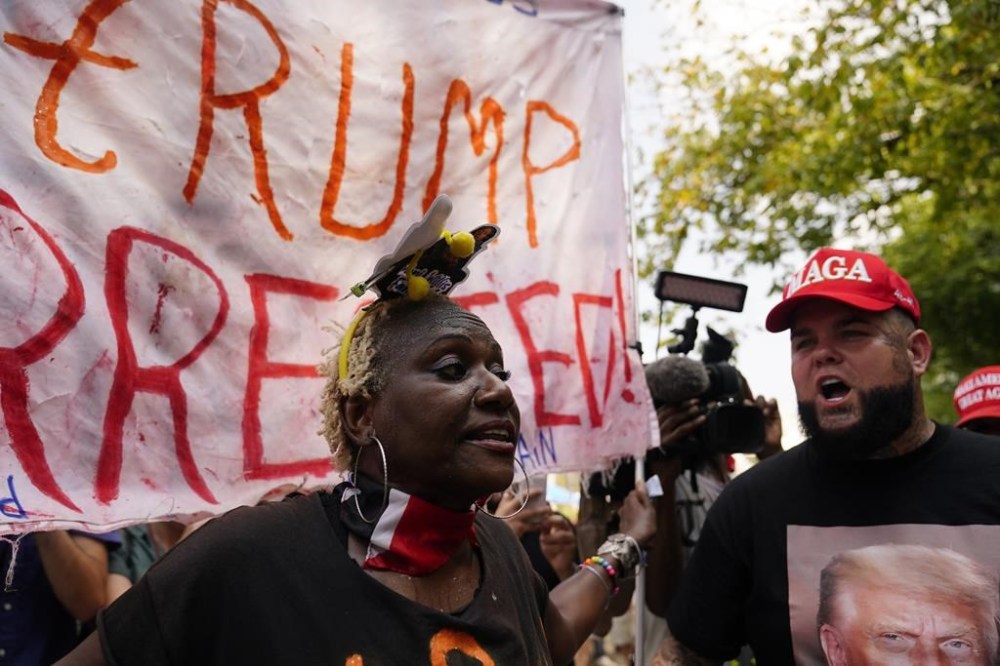 A protester on the left, chants against a supporter of former President Donald Trump, right, near the Fulton County Jail, Thursday, Aug. 24, 2023, in Atlanta. (AP Photo/Brynn Anderson)