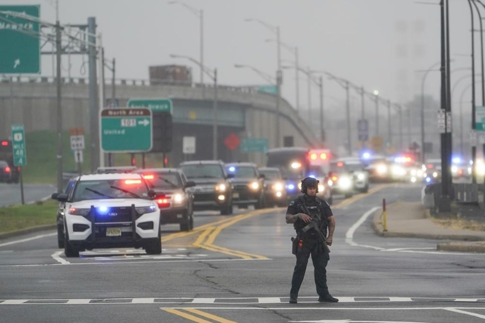 A police officers stands in the road as a motorcade for former President Donald Trump arrives to Newark Liberty International Airport in Newark, N.J., Thursday, Aug. 24, 2023. (AP Photo/Seth Wenig)