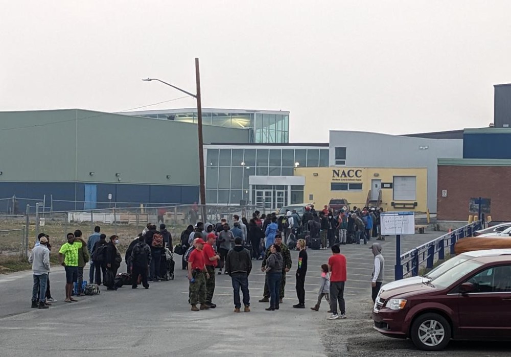 People without vehicles lineup to register for a flight to Calgary, Alberta, in Yellowknife on Thursday, August 17, 2023. The premiers of Alberta and the Northwest Territories are scheduled to tour a Calgary reception centre for wildfire evacuees from the territory this afternoon. THE CANADIAN PRESS/Bill Braden