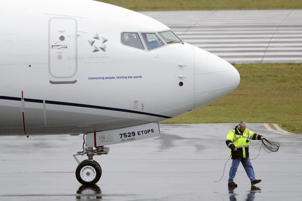 FILE - A worker coils up the cord for a flight deck communications headset as a United Airlines Boeing 737 Max airplane prepares to take off, Wednesday, Dec. 11, 2019, at Renton Municipal Airport in Renton, Wash. Federal safety regulators are warning airlines to make sure that workers stay away from jet engines that are still running. The Federal Aviation Administration said Friday, Aug. 25, 2023, that the alert follows “multiple