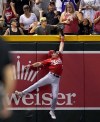 A young fan pulls the ball out of the glove of Cincinnati Reds' Spencer Steer on a ball hit by Arizona Diamondbacks' Tommy Pham during the seventh inning of a baseball game, Friday, Aug. 25, 2023, in Phoenix. The Fan was called for interference on the play and was ejected from the ballpark. (AP Photo/Matt York)