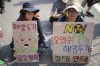 Protesters hold signs during of a rally to demand the stop of the Japan's release of treated radioactive water into the sea from the damaged Fukushima nuclear power plant and denounce the South Korean government's policy in Seoul, South Korea, Saturday, Aug. 26, 2023. The letters read 