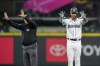 Seattle Mariners' Julio Rodriguez, right, mimics a gesture by second base umpire Jeff Nelson, left, after hitting an RBI double to score J.P. Crawford against the Oakland Athletics during the third inning of a baseball game Monday, Aug. 28, 2023, in Seattle. (AP Photo/Lindsey Wasson)