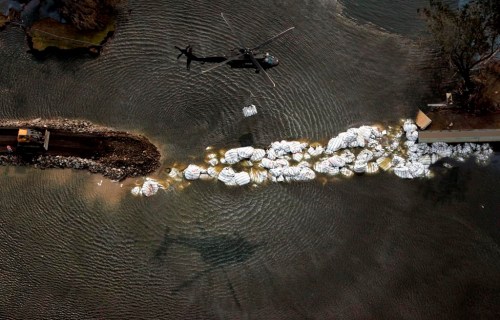 FILE - In this Sept. 5, 2005, file photo, a military helicopter drops a sandbag as work continues to repair the 17th Street canal levee in New Orleans, in the aftermath of Hurricane Katrina. Eighteen years after floodwaters pushed by Katrina inundated most of New Orleans, a nonprofit group is launching an effort to make sure engineering students learn about the federal levee design and construction failures that gave rise to one of the nation's deadliest and costliest disasters. (AP Photo/David J. Phillip, File)