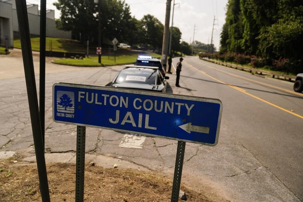 FILE - A Fulton County Jail signs points to where the jail is located, Thursday, Aug. 24, 2023, in Atlanta. Authorities say a 34-year-old man who was being held at the problem-plagued Fulton County Jail died after being taken to a hospital. He was the fourth person to die in county custody in the span of a month. (AP Photo/Brynn Anderson, File)