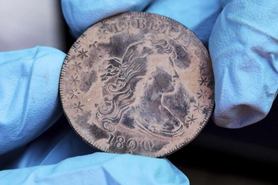 West Point archeologist Paul Hudson displays an 1800 Draped Bust Dollar. (U.S. Military Academy at West Point via The Associated Press)