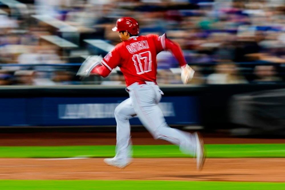 Los Angeles Angels' Shohei Ohtani (17), of Japan, advances to third base on a sacrifice fly by Brandon Drury during the third inning of the team's baseball game against the New York Mets, Friday, Aug. 25, 2023, in New York. (AP Photo/Frank Franklin II)