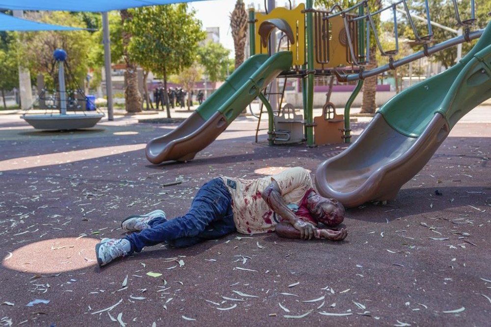 A supporter of the Eritrean government lies injured and covered in blood after he was hurt by an Anti-Eritrean government activist, during a protest against an event organized by the Eritrea Embassy in Tel Aviv, Israel, Saturday, Sept. 2, 2023. Hundreds of Eritrean asylum seekers smashed shop windows and police cars in Tel Aviv on Saturday and clashed with police during a protest against an event organized by the Eritrea Embassy. The Israeli police said 27 officers were injured in the clashes, and at least three protesters were shot when police opened fire with live rounds when they felt