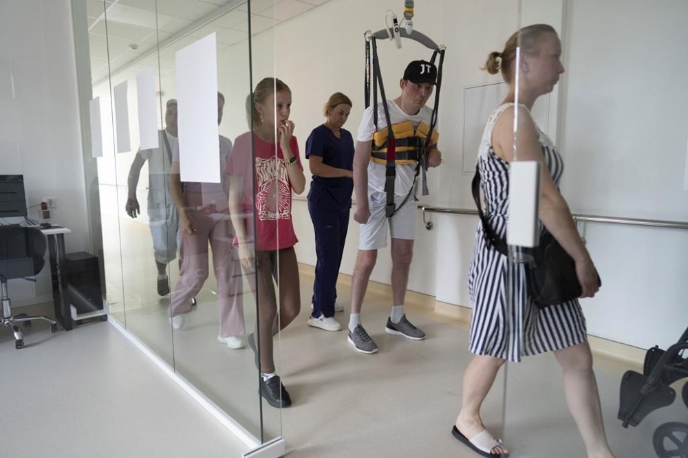 Oleksandr Ivanov, a 41-year-old Ukrainian serviceman, learns to walk at the rehabilitation center in St. Panteleimon hospital in Lviv, Ukraine, Monday, July 24, 2023. Ivanov was in the Zaporizhzhia region when he was injured in the head and right side on June 5, 2022, in a mine explosion. Ukraine is facing the prospect of a future with upwards of 20,000 amputees, many of them soldiers who are also suffering psychological trauma from their time at the front. (AP Photo/Evgeniy Maloletka)