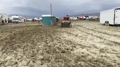 In this image from video provided by Rebecca Barger a vehicle drives through mud at the Burning Man festival site in Black Rock, Nev., on Monday, Sept. 4, 2023. An unusual late-summer storm stranded thousands at the week-long event. (Rebecca Barger/@rebeccabargerphoto via AP)