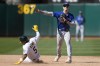 Toronto Blue Jays second baseman Cavan Biggio, top, throws to first base after forcing Oakland Athletics' Tony Kemp (5) out at second base on a double play hit into by Zack Gelof during the tenth inning of a baseball game in Oakland, Calif., Monday, Sept. 4, 2023. (AP Photo/Jeff Chiu)