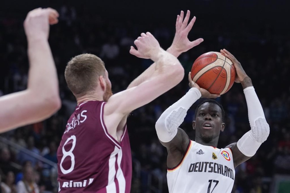 Germany guard Dennis Schroder (17), right, takes a shot at goal as Latvia forward Davis Bertans (8) attempts to block during the Basketball World Cup quarterfinal between Germany and Latvia in Manila, Philippines, Wednesday, Sept. 6, 2023. (AP Photo/Michael Conroy)