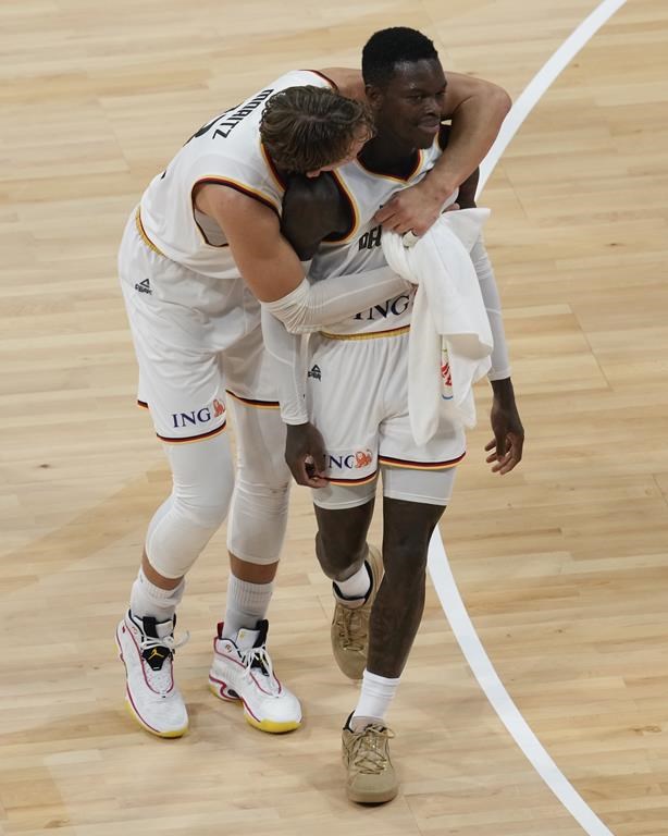 German forward Moritz Wagner (13) embraces teammate Dennis Schroder (17), right, after they defeated Latvia in their Basketball World Cup quarterfinal in Manila, Philippines, Wednesday, Sept. 6, 2023. (AP Photo/Aaron Favila)