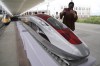FILE - A woman to take photos of a model high-speed train at the Jakarta-Bandung Fast Railway station in Tegalluar, West Java, Indonesia, Thursday, Oct. 13, 2022. Chinese Premier Li Qiang has taken a test ride on Southeast Asia’s first high-speed railway, which connects two Indonesian cities as part of China’s Belt and Road infrastructure initiative. Li is visiting Jakarta for two days of talks with leaders of the Association of Southeast Asia Nations and other countries. (AP Photo/Dita Alangkara, File)