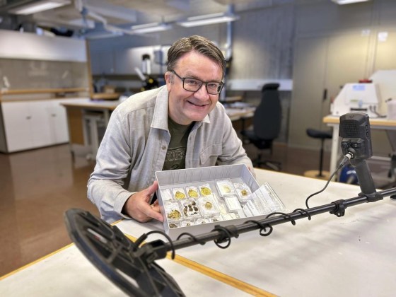 Erlend Bore poses with the gold treasure he discovered with a metal detector on the island of Rennesoey in Stavanger, Norway. (Anniken Celine Berger/Archaeological Museum, UiS via NTB via The Associated Press)