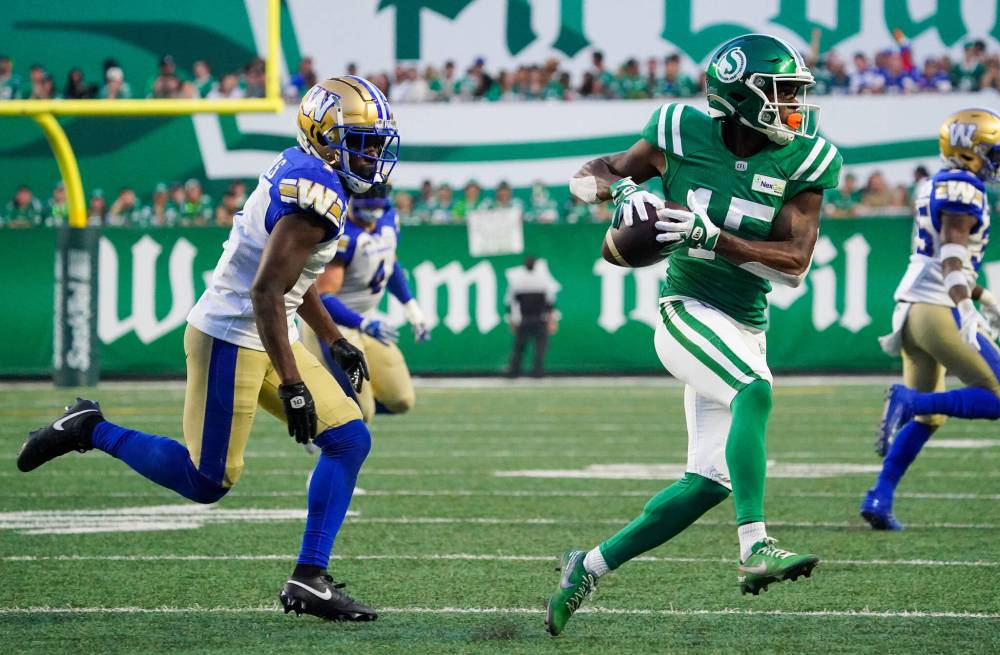 Saskatchewan Roughriders receiver Shawn Bane Jr. (15) runs the football as Winnipeg Blue Bombers defensive back Deatrick Nichols (1) runs during the second half of CFL Labour Day Classic football action in Regina, Sunday, Sept. 3, 2023. (Heywood Yu / The Canadian Press)