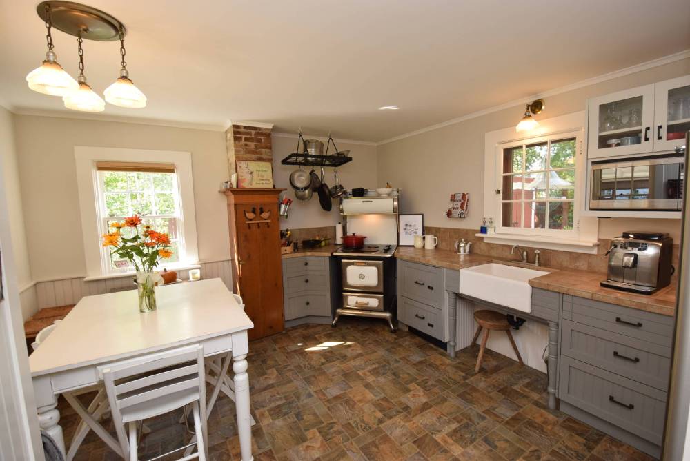 <p>A farmhouse-style sink and vintage Heartland stove give the kitchen a country-modern feel.</p>