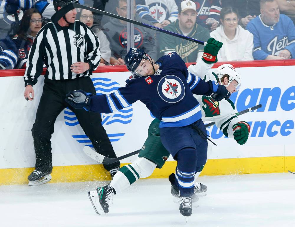 THE CANADIAN PRESS FILES/John Woods
Winnipeg Jets’ Neal Pionk and Minnesota Wild’s Mason Shaw collide during NHL action in Winnipeg, March 8, 2023. Pionk says when it comes to judging the quality of his play in the NHL, he is his own worst critic, but he is making inroads at being more positive.