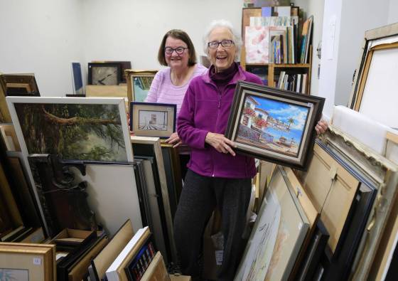Sharon Twilley, co-chair of Grands ‘n’ More, left, and Jean Altemeyer, co-coordinator of the annual Art From the Attic event, with some of the art that will be for sale on Oct. 15. (Ruth Bonneville / Winnipeg Free Press)