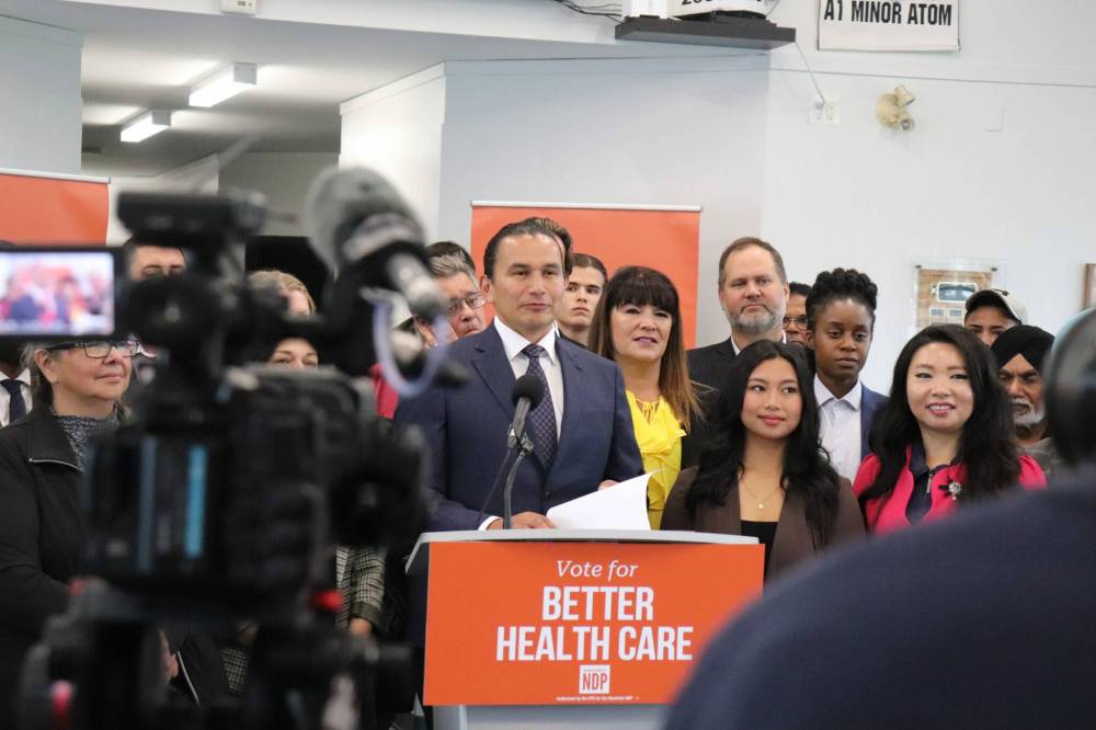 NDP Leader Wab Kinew flanked by party members at the Tuxedo Community Centre earlier this month. (Tyler Searle / Winnipeg Free Press)