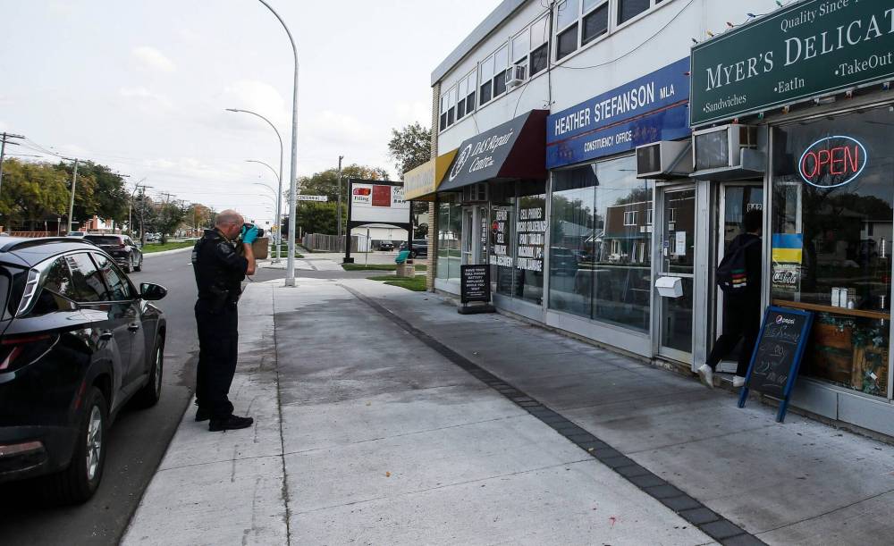 JOHN WOODS / WINNIPEG FREE PRESS
A police officer collects evidence at the vandalized constituency office of PC leader Heather Stefanson in Winnipeg Tuesday.