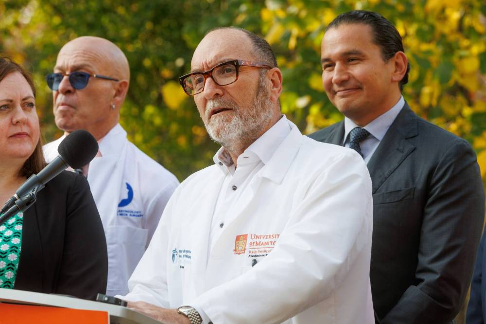 NDP leader Web Kinew (right) listens to Dr. Eric Jacobsohn (centre) speak on Wednesday morning. (Mike Deal / Winnipeg Free Press)