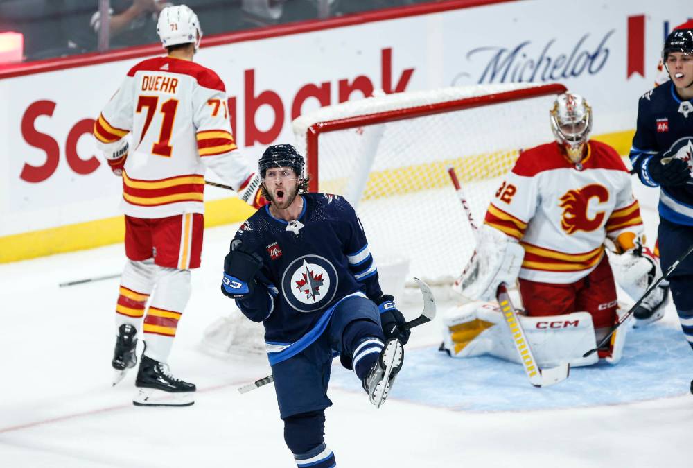 JOHN WOODS /THE CANADIAN PRESS
Winnipeg Jets’ Jansen Harkins (12) celebrates his goal against Calgary Flames goaltender Dustin Wolf (32) during first period NHL pre-season game action in Winnipeg, Wednesday, Sept. 27, 2023.