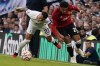Manchester United's Jadon Sancho, right, and Tottenham's Pedro Porro challenge for the ball during the Premier League soccer match between Tottenham Hotspur and Manchester United at the Tottenham Hotspur Stadium in London, England, Saturday, Aug. 19, 2023. (AP Photo/Alberto Pezzali)