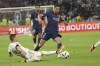 PSG's Achraf Hakimi, centre, and Lyon's Nicolas Tagliafico challenge for the ball during the French League One soccer match between Lyon and Paris Saint-Germain at the Groupama stadium, outside Lyon, France, Sunday, Sept. 3, 2023. (AP Photo/Laurent Cipriani)