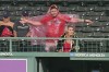 A baseball fan stretches as he puts on a poncho during a rain delay at a baseball game between the New York Yankees and the Boston Red Sox, Monday, Sept. 11, 2023, in Boston. (AP Photo/Steven Senne)