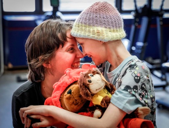 Bridget Penney, left, and her daughter Mira Penney, 10, share a moment while taking part in an exercise session. (Jeff McIntosh / The Canadian Press)