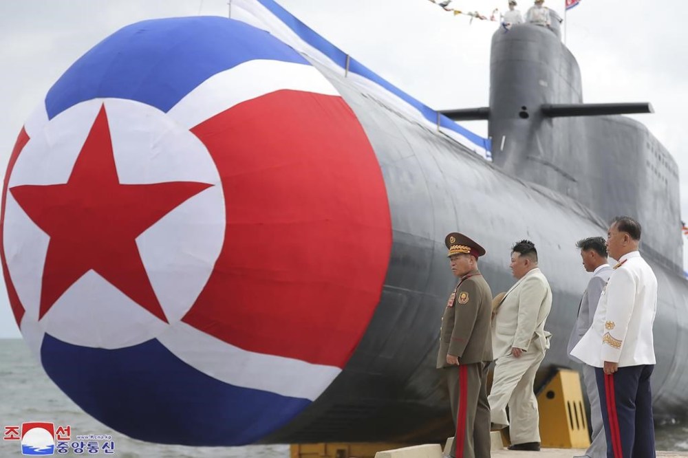 FILE - In this photo provided by the North Korean government, North Korea leader Kim Jong Un, second left, looks at what it says is a new nuclear attack submarine