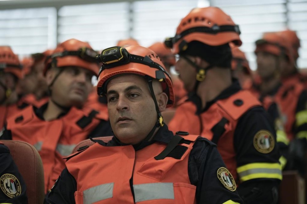 Palestinian civil defense team members listen to a briefing before leaving for a mission to assist flood-stricken Libya, in the West Bank city of Ramallah, Wednesday, Sept. 13, 2023. Palestinian medics and civil defense forces are headed to Libya to join relief and assistance efforts for victims affected by the cyclone that devastated the country. (AP Photo/Majdi Mohammed)
