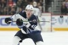 Winnipeg Jets defenceman Declan Chisholm flips the puck ahead against the Detroit Red Wings in the first period of an NHL hockey game Thursday, Jan. 13, 2022, in Detroit. The Jets have signed Chisholm to a one-year, two-way contract on Wednesday. THE CANADIAN PRESS/AP-/Paul Sancya