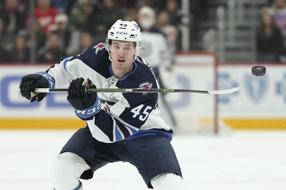 Winnipeg Jets defenceman Declan Chisholm flips the puck ahead against the Detroit Red Wings in the first period of an NHL hockey game Thursday, Jan. 13, 2022, in Detroit. The Jets have signed Chisholm to a one-year, two-way contract on Wednesday. THE CANADIAN PRESS/AP-/Paul Sancya