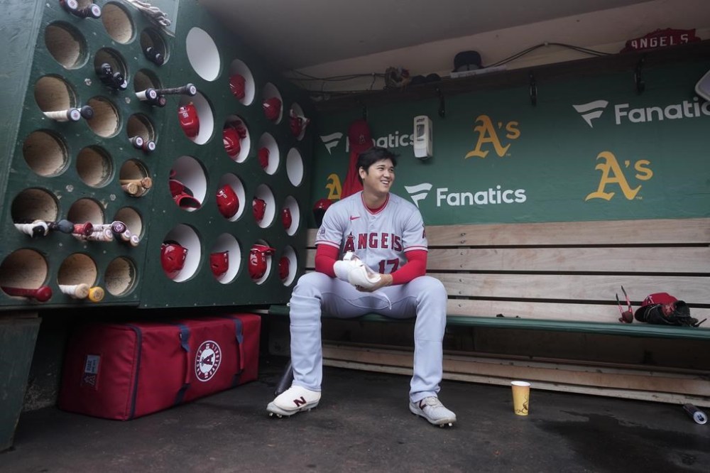FILE - Los Angeles Angels' Shohei Ohtani sits in the dugout before the team's baseball game against the Oakland Athletics in Oakland, Calif., Sept. 2, 2023. Ohtani likely has the AL MVP race wrapped up. His two-way prowess was derailed by a torn elbow ligament in August, but for five months, he treated baseball fans to one of the most impressive performances in MLB history. (AP Photo/Jeff Chiu, File)