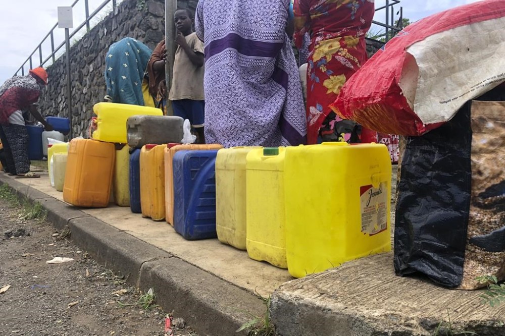 FILE - People queue to fill up containers with water in Tsoundzou, Mayotte island, Saturday Feb.6, 2021 during the Covid pandemic. France is sending military forces to distribute water on the French Indian Ocean territory of Mayotte, which is facing an unprecedented water crisis prompted by the island's most severe drought in decades. Troops with the French Foreign Legion and French navy based in the region will work with local authorities to ensure water supplies to local populations, the Defense Ministry said in a statement Thursday Sept. 14, 2023. (AP Photo/ Sony Ibrahim Chamsidine, File)