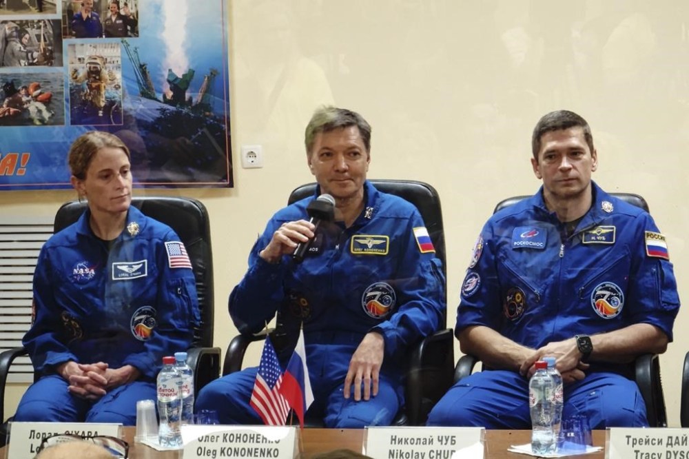 In this photo released by Roscosmos space corporation Roscosmos, cosmonauts Oleg Kononenko, centre, Nikolai Chub, right, and NASA astronaut Loral O'Hara, left, crew members of the new mission to the International Space Station, ISS, attend a news conference behind a safety glass in Russian leased Baikonur cosmodrome, Kazakhstan, Thursday, Sept. 14, 2023. The new Soyuz mission to the International Space Station is scheduled on Friday, Sept. 15. (Roscosmos space corporation, via AP)