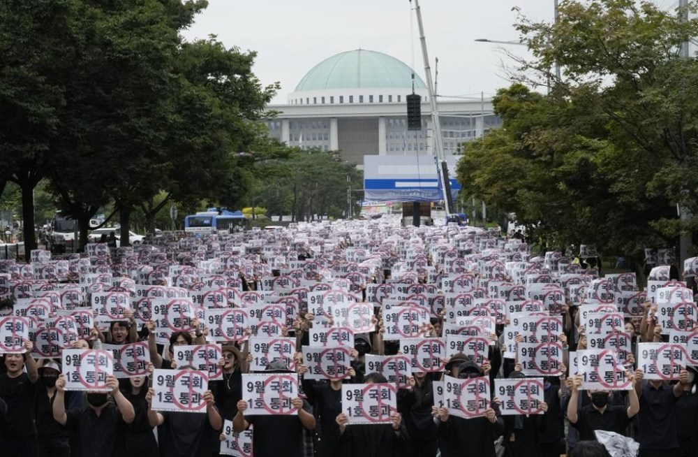 Teachers hold up their banners during a rally to demand the better protection of their rights near the National Assembly in Seoul, South Korea, Saturday, Sept. 16, 2023. Following the suicide of an elementary school teacher in July, teachers across South Korea have been pushing for improved systems to protect teachers from widespread malicious complaints from parents. The signs read