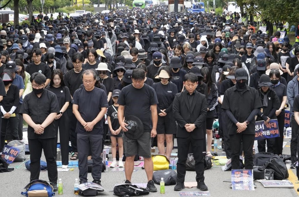 Teachers pay silent tribute to a late female teacher during a rally to demand the better protection of their rights near the National Assembly in Seoul, South Korea, Saturday, Sept. 16, 2023. Following the suicide of an elementary school teacher in July, teachers across South Korea have been pushing for improved systems to protect teachers from widespread malicious complaints from parents. (AP Photo/Ahn Young-joon)