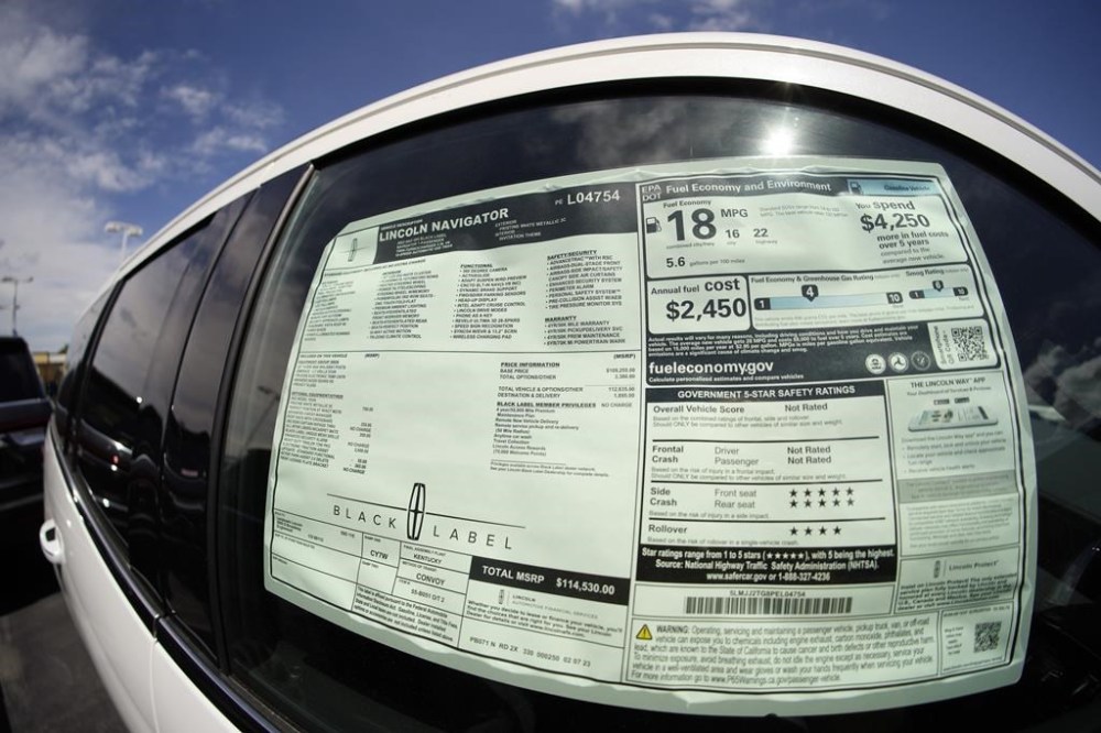 File - The sticker price is displayed in the window of an unsold 2023 Navigator sports-utility vehicle at a Lincoln dealership on June 18, 2023, in Englewood, Colo. The strike by auto workers is almost certain to lead to higher prices for car buyers; it's only a matter of whether panic buying will make dealer lots look empty sooner than analysts expect. (AP Photo/David Zalubowski, File)