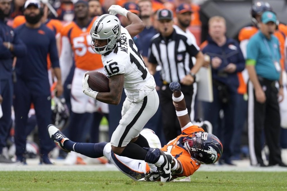 Las Vegas Raiders wide receiver Jakobi Meyers (16) breaks away from Denver Broncos cornerback Damarri Mathis during the first half of an NFL football game, Sunday, Sept. 10, 2023, in Denver. (AP Photo/David Zalubowski)