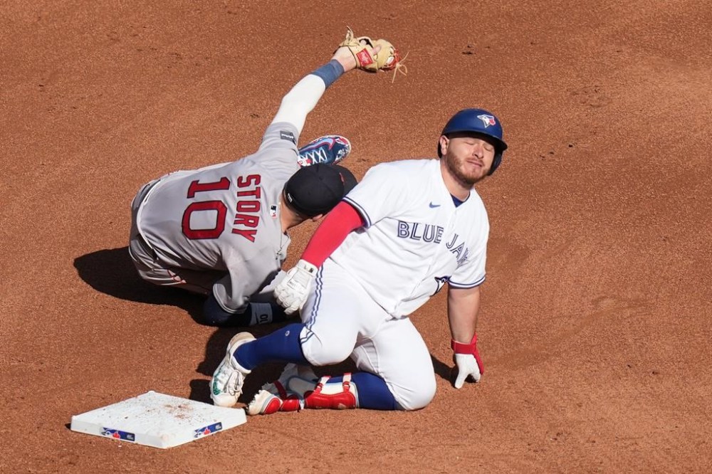 Toronto Blue Jays' Alejandro Kirk reacts as he tagged out at second base by Boston Red Sox shortstop Trevor Story after trying to stretch a single into a double during fifth inning American League MLB baseball action in Toronto on Saturday, September 16, 2023. THE CANADIAN PRESS/Chris Young