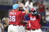 Miami Marlins' Yuli Gurriel, right, is met at the plate by Jake Burger (36) and Josh Bell, center, after hitting a three-run home run during the first inning of a baseball game against the Atlanta Braves, Saturday, Sept. 16, 2023, in Miami. (AP Photo/Lynne Sladky)