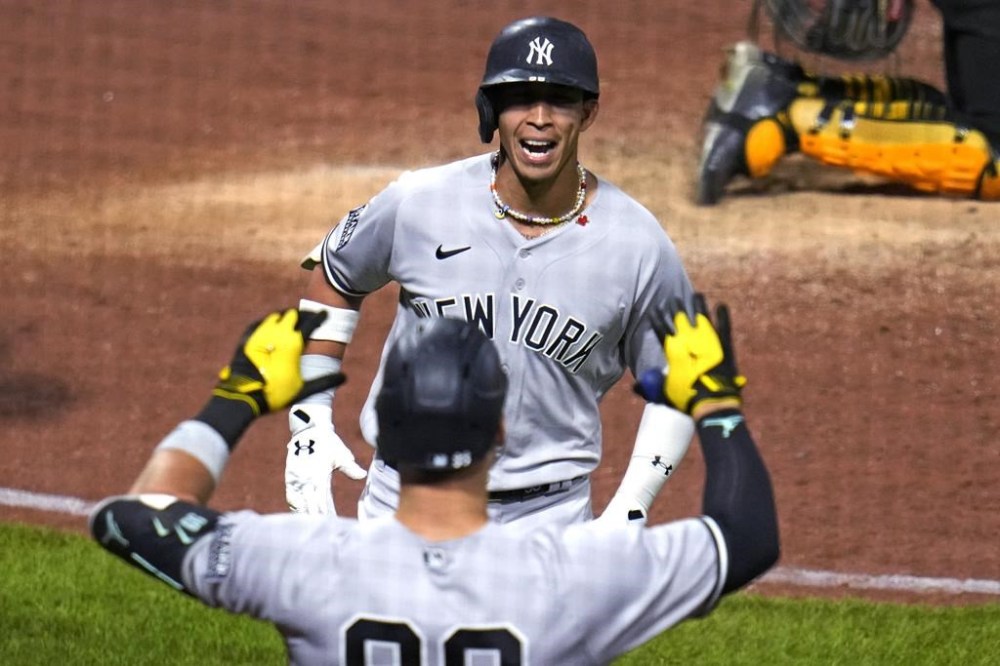 New York Yankees' Oswaldo Cabrera, top, is greeted by Aaron Judge as he returns to the dugout after hitting a solo home run off Pittsburgh Pirates relief pitcher Thomas Hatch during the eighth inning of a baseball game in Pittsburgh, Saturday, Sept. 16, 2023. (AP Photo/Gene J. Puskar)