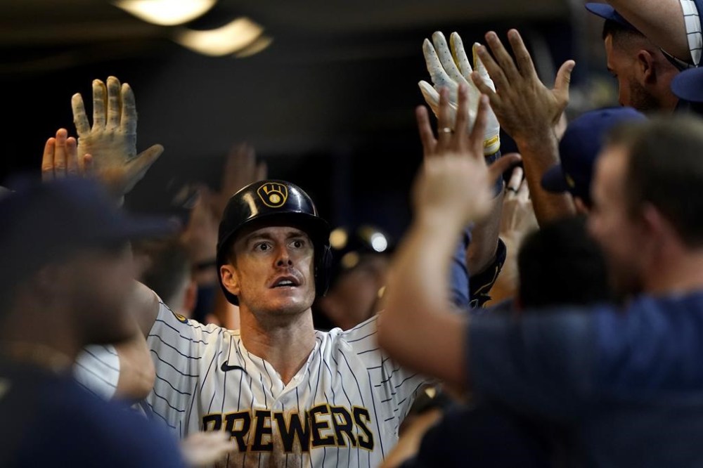 Milwaukee Brewers' Mark Canha is congratulated in the dugout after hitting a grand slam during the eighth inning of a baseball game against the Washington Nationals, Saturday, Sept. 16, 2023, in Milwaukee. (AP Photo/Aaron Gash)