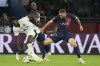 Nice's Evann Guessand, left, challenges for the ball with PSG's Milan Skriniar during the French League One soccer match between Paris Saint Germain and Nice at Parc des Princes stadium in Paris, Friday, Sept. 15, 2023. (AP Photo/Michel Euler)